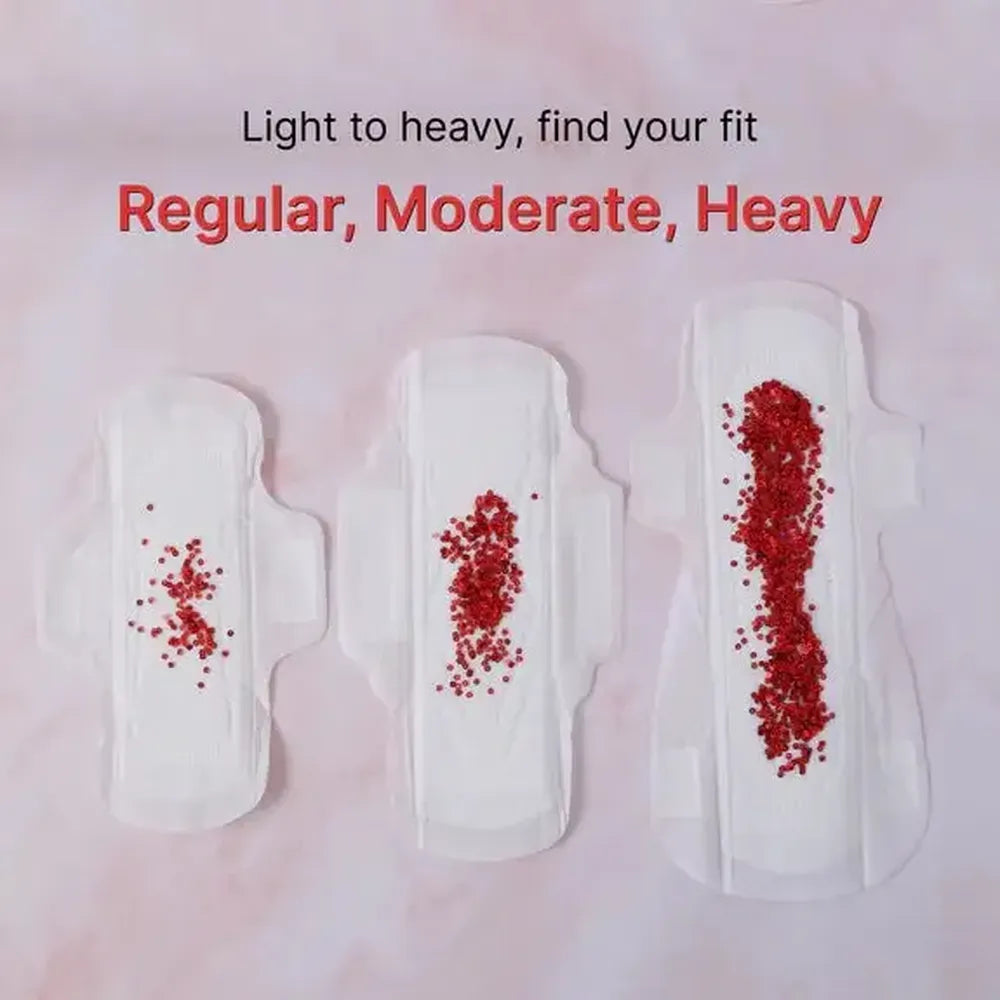 Three menstrual pads with varying amounts of red powder to represent different flow levels on a light pink background.