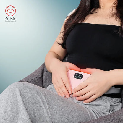 A person sitting and holding a BeMe branded heating pad and electric massager on their lap.