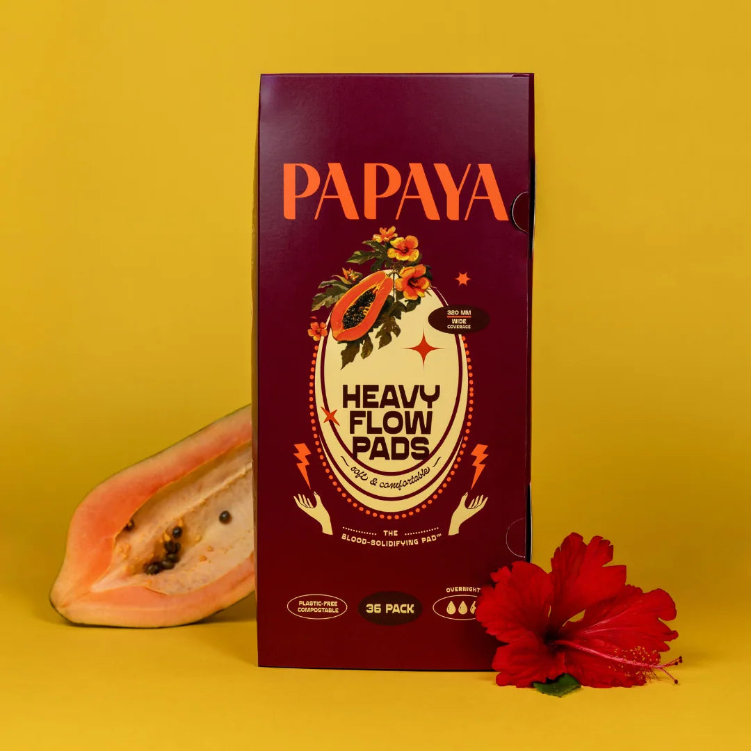 Box of Papaya Heavy Flow Pads on a yellow background with a papaya and red flower.
