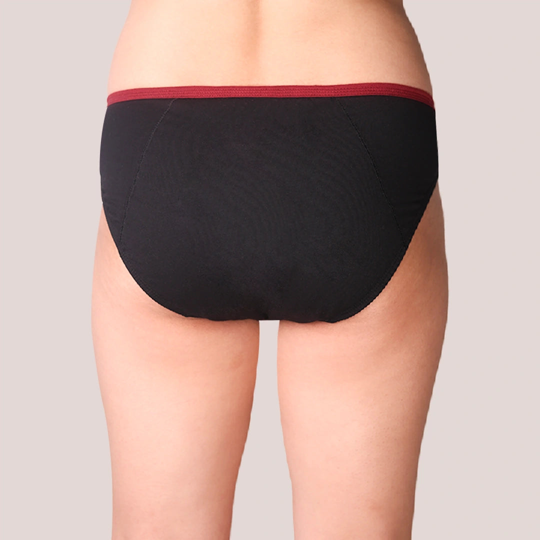 Black period underwear with red waistband on a neutral background