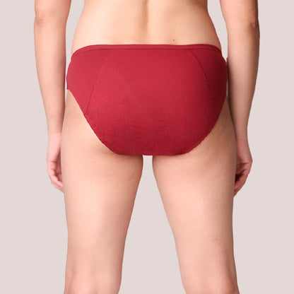 Red period underwear worn by a person on a plain background